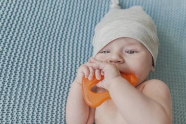 Oyuncak çiğneme teether ile oynayan erkek bebek. Diş çıkarma halkası oyuncak çiğneme bebeğim. bebek çocuk teether oyuncak üstten görünüm kullanarak döşeme