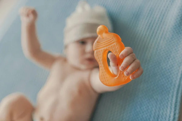 赤ちゃんの男の子の歯がため 遊んでおもちゃを噛みます 赤ちゃんのおしゃぶりおもちゃを噛んでします 歯がためグッズ トップ ビューを使用して男の子を敷設 — ストック写真
