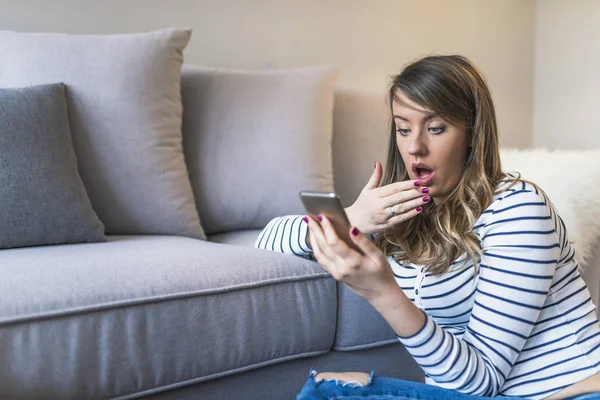 SMS. portre portre komik endişeli korkmuş genç kız telefon kötü haber fotoğraf iletisi iğrenç duygu ile yüzünü görüyor bakarak şok. İnsan tepkisi, ifade. Kadın evde oturma odasında şok edici metin okuma