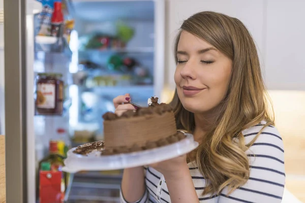 Крупный План Молодой Женщины Стоящей Перед Открытым Холодильником Поедающей Торт — стоковое фото