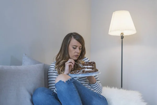 Depressed woman eats cake.  Sad unhappy woman eating cake. Sad woman eating sweet cake. Close up of woman eating chocolate cake. food, junk-food, culinary, baking and holidays concept