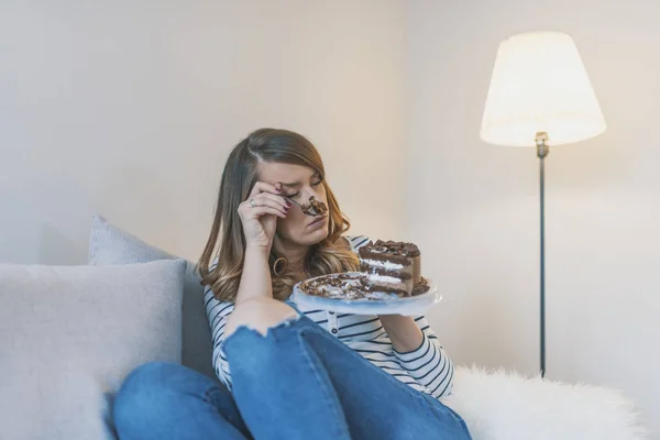 Depressed woman eats cake.  Sad unhappy woman eating cake. Sad woman eating sweet cake. Close up of woman eating chocolate cake. food, junk-food, culinary, baking and holidays concept