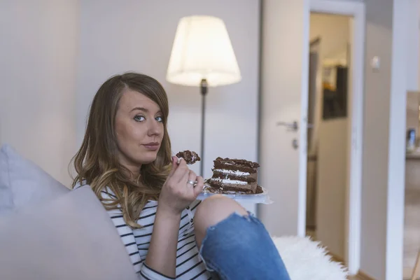 Closeup of woman eating chocolate cake. Beautiful girl enjoys eating a cake with chocolate. Pretty young woman eats a sweet cake. food, junk-food, culinary, baking and holidays concept. woman eating chocolate cake with spoon