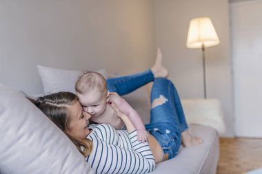 Mutlu sevgi dolu aile. Genç anne bebek oğlu ile oynuyor. Anne ve çocuk yatağa eğleniyorlar... Şirin anne ve çocuk çocuk oyun birlikte evde kapalı. Anne ve bebek çocuk bezi oynarken. Ebeveyn ve çocuk evde rahatlatıcı. Aile ha
