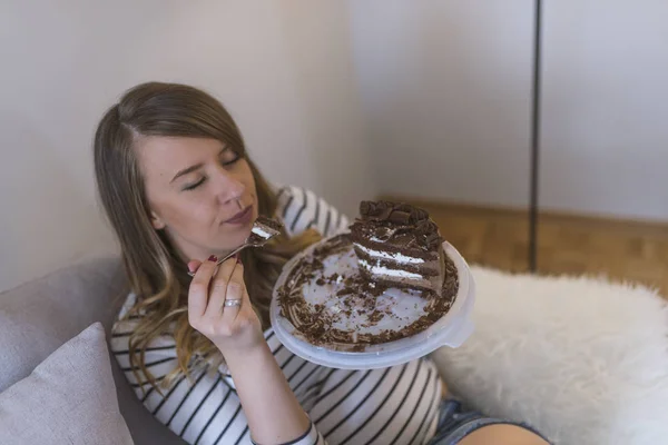 Closeup of woman eating chocolate cake. Beautiful girl enjoys eating a cake with chocolate. Pretty young woman eats a sweet cake. food, junk-food, culinary, baking and holidays concept. woman eating chocolate cake with spoon
