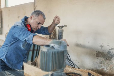 Marangoz, marangoz dükkanında marangozluk yapıyor..