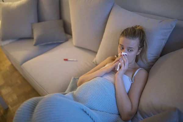 自宅のソファーにはハンカチでインフルエンザに苦しんで怒って若い妊婦 — ストック写真