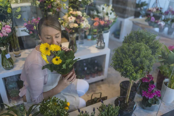 Linda Florista Femenina Joven Olfateando Flores Amarillas Tienda Flores — Foto de Stock