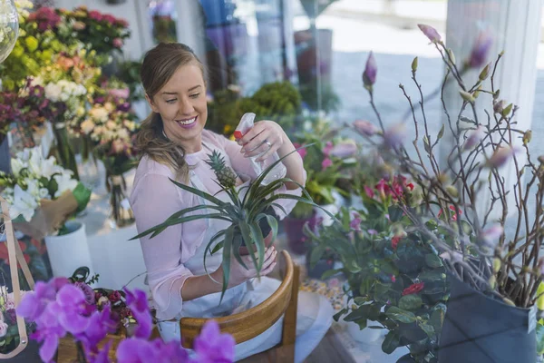 欢乐迷人的年轻女子花店浇水植物 — 图库照片