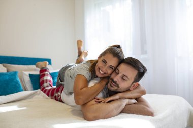 Yatakta birlikte yatan genç çifti yakından çek. Aşık romantik bir çift. Gözlerde aşk. Yatakta mutlu bir çift. Kopya için yer var. Genç, heteroseksüel bir çift yatak odasında yatıyor.