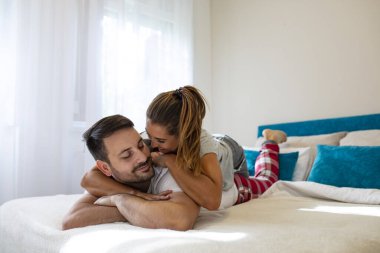 Yatakta birlikte yatan genç çifti yakından çek. Aşık romantik bir çift. Gözlerde aşk. Yatakta mutlu bir çift. Kopya için yer var. Genç, heteroseksüel bir çift yatak odasında yatıyor.
