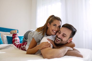 Mutlu çift yatakta birlikte yatıyor. Birbirimizin arkadaşlığından keyif alıyoruz. Yatakta sevişen çiftin duygusal ön sevişmesi. Yatakta mutlu genç bir çift. Sevişen çift.