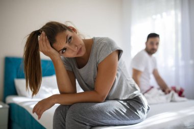 Yatakta tartışan ve cinsel sorunları olan bir çift. Yatak odasında mutsuz, heteroseksüel bir çiftin portresi. Fotoğrafta genç bir kadın ve erkeğinin yatak odasında sorun yaşadığı görülüyor.