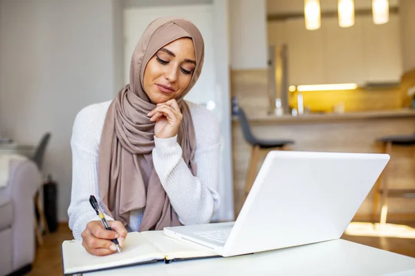 イスラム教徒の女性がノートパソコンをスクロールし オンライン教育 技術で働いています オフィスの職場でヒジャーブの幸せなイスラム教徒のビジネス女性 スタートアッププロジェクトのノートパソコンで働くアラビア人女性の笑顔 コピースペース — ストック写真