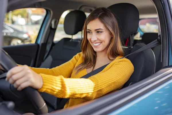 美しい若い幸せな笑顔の女性は日没時に彼女の新しい車を運転する 車を運転している間に美人の女の子が笑っている 若いです美しいです女の子とともに素敵な笑顔車を運転 — ストック写真