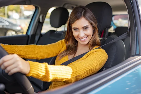 美しい若い幸せな笑顔の女性は日没時に彼女の新しい車を運転する 車を運転している間に美人の女の子が笑っている 若いです美しいです女の子とともに素敵な笑顔車を運転 — ストック写真