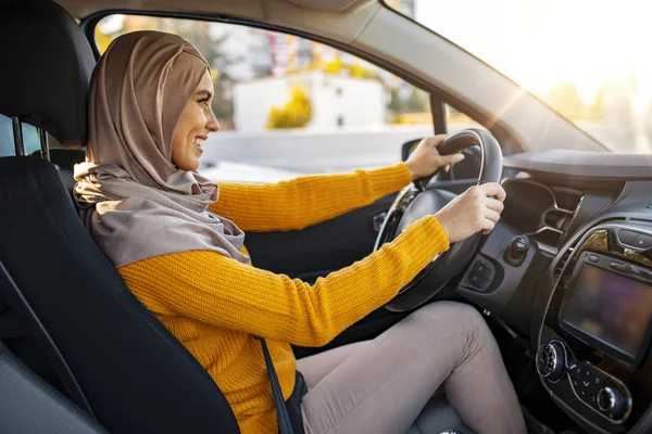 Geleneksel gülümseyen Arap kadın yeni araba deniyor. Arabasını süren genç müslüman bir kadının portresi. Araba kullanan Arap kadınlar.