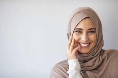 Başörtüsü gülüşlü Asyalı genç Müslüman kadın. Abaya giyen güzel bir ortadoğu kadını. Gülümseyen Arap bir kadın. Sıkı bir resmi kıyafet ve şık bir görünüş. İslami moda.