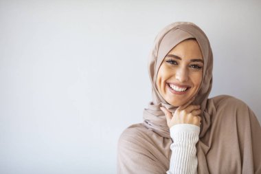 Gülümseyen İslami kadın portresi. Güzel Müslüman kız. Gri duvar stüdyosunda poz veren güzel Asyalı müslüman kadın model. Arap Güzelliğinin Portresi. 