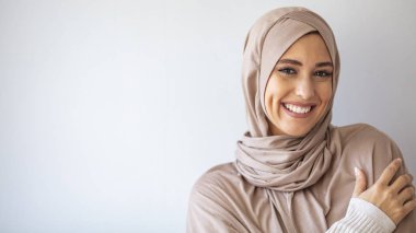 Gülümseyen İslami kadın portresi. Güzel Müslüman kız. Gri duvar stüdyosunda poz veren güzel Asyalı müslüman kadın model. Arap Güzelliğinin Portresi. 