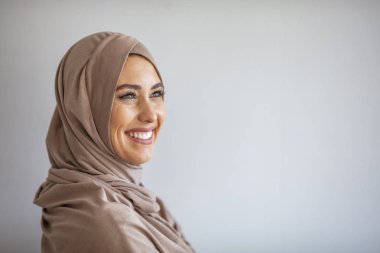 Güzel Müslüman kadın poz veriyor ve gülümsüyor. Başörtüsü takan güzel bir müslüman kadının portresi. Kafasına tesettür takmış güzel bir Müslüman kadın. 
