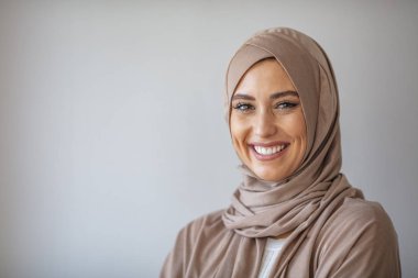 Geleneksel Müslüman kıyafetleri içinde gülümseyen genç bir kadının portresi. Kameraya bakıp tesettürlü güzel bir kadın. Gülümseyen Arap bir kadın. Sıkı bir resmi kıyafet ve şık bir görünüş. İslami moda.