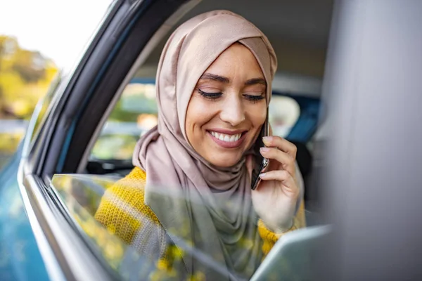 Młoda Muzułmańska Bizneswoman Rozmawiająca Przez Telefon Tylnym Siedzeniu Samochodu Trzymająca — Zdjęcie stockowe