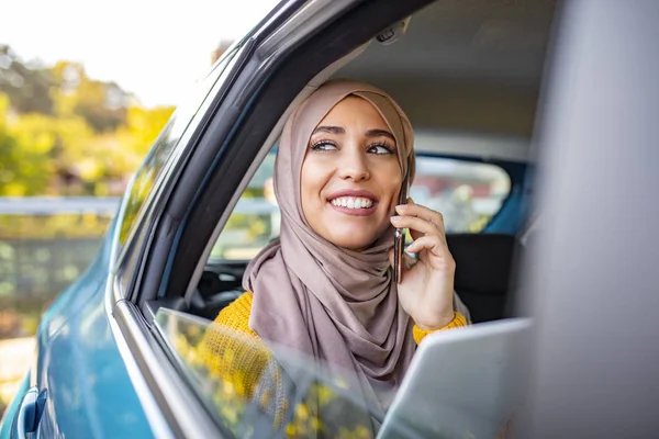 Młoda Piękna Muzułmanka Siedząca Tylnym Siedzeniu Samochodu Tabletem Ręku Rozmawiająca — Zdjęcie stockowe