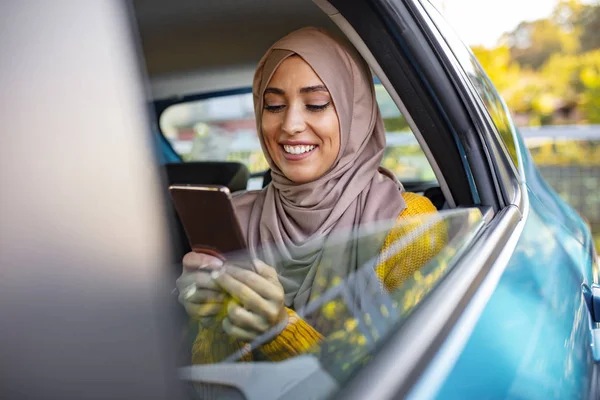 Muzułmańska Bizneswoman Samochodzie Pisze Wiadomość Komórce Pozytywny Zamyślony Islamska Kobieta — Zdjęcie stockowe