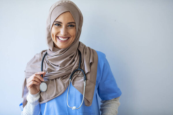 Confident female nurse. Confident Muslim female doctor standing with isolated gray. Closeup portrait of friendly, smiling confident muslim female doctor. Portrait of Muslim nurse with stethoscope