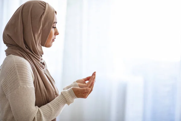 ベージュヒジャーブのイスラム教徒の女性と伝統的な服は 神のために祈る スペースをコピーします 明るい窓で屋内を祈るヒジャーブを持つイスラム教徒の女性 若いムスリム女性の祈り — ストック写真
