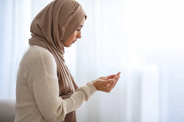 若い女性の祈り 若いムスリム女性が屋内で祈っています ベージュヒジャーブの若いイスラム教徒の女性と伝統的な服は 神のために祈る スペースをコピーします アラブムスリム女性の祈り — ストック写真