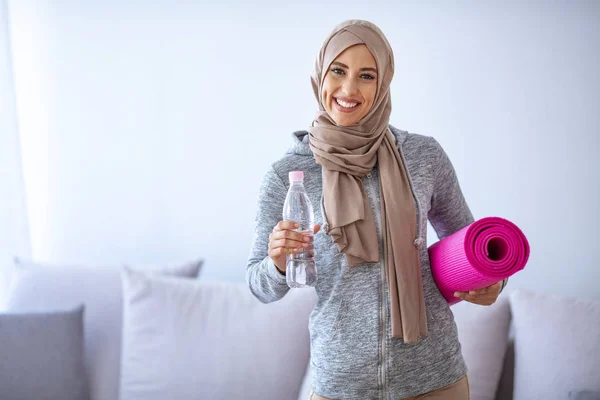 Muslim woman preparing for workout. Young muslim woman ready to running. Islamic woman resting and drinking water. Portrait of muslim woman likes her active life