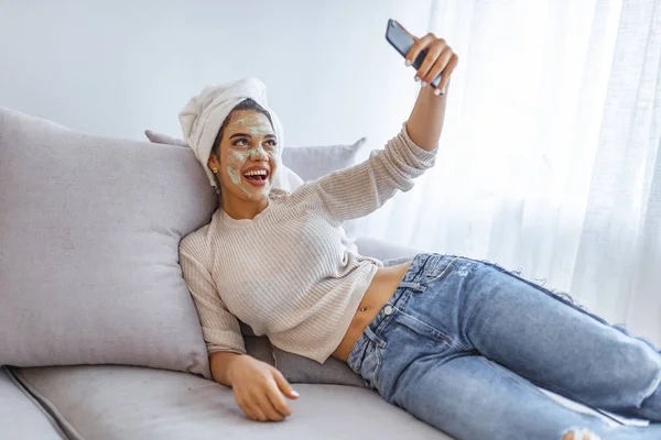Дівчина Маскою Краси Розслабляється Вдома Повідомляючи Текст Мобільному Телефоні Молода — стокове фото