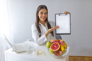 Meyveli doktor beslenme uzmanı ve elinde boş bir pano, sağlıklı beslenme ve zayıflatma konsepti var. Doğru beslenme menüsü için maket, kopyalama alanı. Etkili diyet menüsü ve zayıflatma programı. 