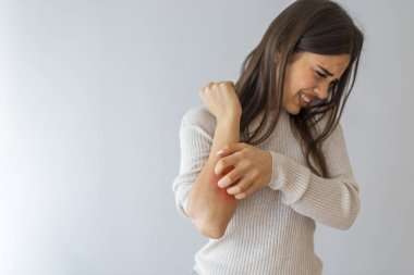 Beyaz arka planda kaşınan bir kadın. Hassas cilt, gıda alerjisi semptomları, tahriş. İnsanlar kaşıntıyı elle, kolla, kaşıntıyla, sağlık ve tıpla kavrayabiliyor..