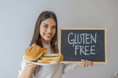 Glüten ve ekmek taşıyan bir kadın. Buğday Hoşgörüsüz Kadın Ekmeğini Kapatın. Glütensiz konsept. Glüten Bedava Yemek Çölyak Hastalığı Beslenme