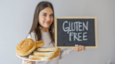 Glüten ve ekmek taşıyan bir kadın. Buğday Hoşgörüsüz Kadın Ekmeğini Kapatın. Glütensiz konsept. Glüten Bedava Yemek Çölyak Hastalığı Beslenme