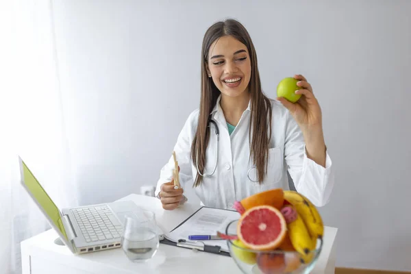 그녀의 책상에서 일하는 과일을 영양사 사무실에서 미소짓는 영양학자는 야채와 관리와 — 스톡 사진