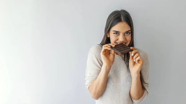 Retrato Una Chica Guapa Satisfecha Mordiendo Barra Chocolate Mirando Cámara — Foto de Stock