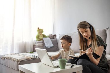 Anne, çocukla evde çalışıyor. Çocuklar gürültü yapıyor ve işyerindeki kadınları rahatsız ediyor. Evde eğitim ve serbest meslek. Anneler işini ve ailesini dengeleyebilir. Çok görevli anne evde çalışıyor.. 