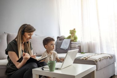 Anne, Covid-19 karantinasında küçük çocuklarla birlikte evden çalışıyor. Anne, çocukla evde çalışıyor. Koronavirüs salgını sırasında karantina ve kapalı okul.