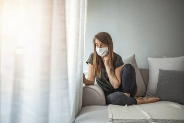 COVID-19 Salgın Coronavirus Maskeli Kadın COVID-19 Evde Karantina Altındaki Kız. Salgın hastalık. Evde tek başına karantinaya alınmış bir kız. salgın hastalık.