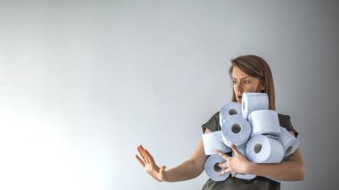 Coronavirus salgını sırasında veya Covid-19 sırasında tuvalet kağıdı saklayan bir kadın. İnsanlar Crownavirus karantinası için tuvalet kağıdı stokluyorlar. Kadının elinde bir sürü tuvalet kağıdı var.