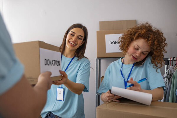 Small group of people working on humanitarian aid project. Group of mixed race people working in charitable foundation. We love to help other people. Generous people helping to poor people