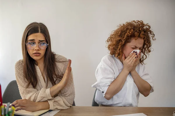 Bilden Affärskvinna Nysningar Medan Hennes Kvinnliga Partner Tittar Henne Osäkert — Stockfoto