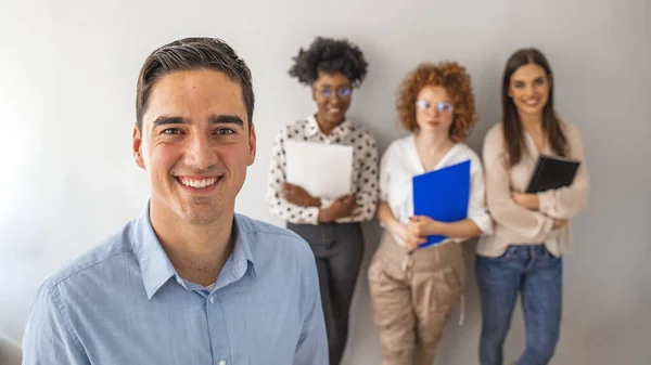 Successful company with happy employees in modern office. Cropped shot of a group of businesspeople standing in the office. Portrait of a confident businessman