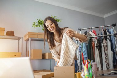 Kadın işi evden yönetiyor. Çevrimiçi kargo alışverişi, gençler iş yerinde karton kutu paketleyen küçük işletme sahipleri olarak başlıyorlar. Çevrimiçi satış veya e-ticaret.