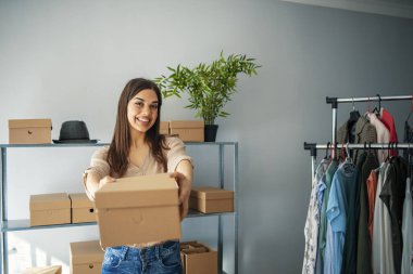Genç, iş yerinde karton kutu paketleyen küçük bir işletme sahibi olarak başlar. Serbest çalışan kadın satıcı, bir paket ürünü müşteriye teslim etmek için hazırlar. Çevrimiçi satış, e-ticaret, nakliye konsepti