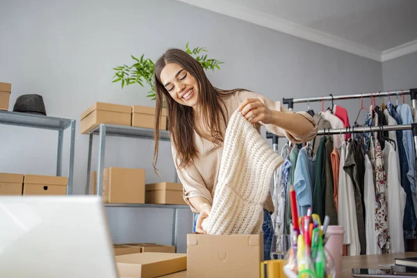 Everyone do shopping online. Woman packing item that she sells online. Women, owener of small business packing product in boxes, preparing it for delivery.